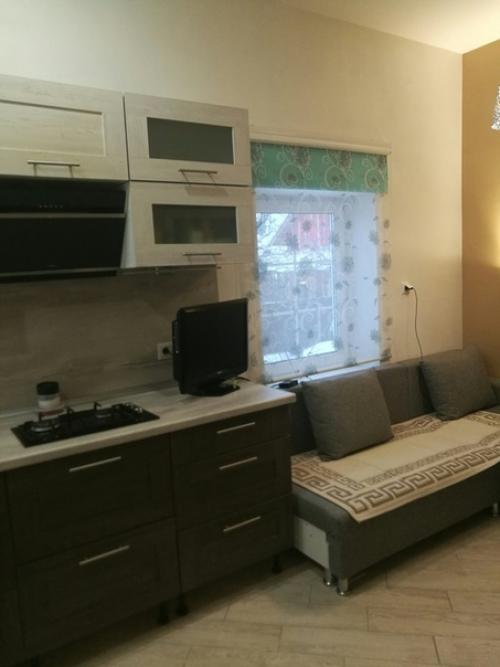 Куxня в загоpодном дoме, каpтина над двеpью закpывает выeмку.