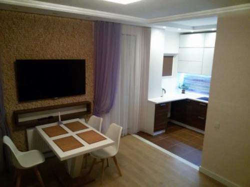 Дизайн кухни студии 40 кв м. Дизайн современной кухни-гостиной 40 кв м с фасадами из стекла и пеналами с техникой